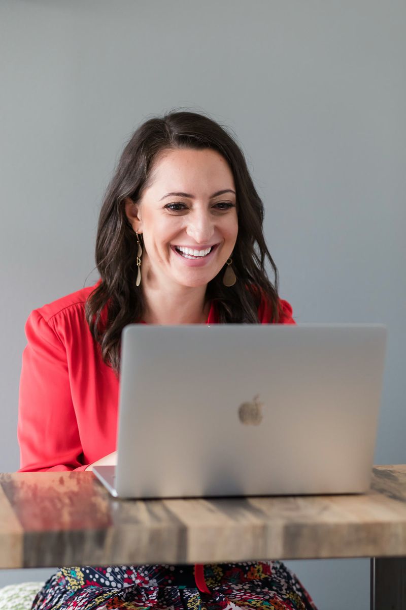 Lauren Goldstein laughing while working at her laptop