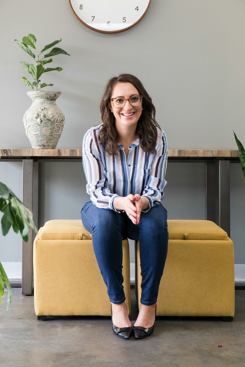 Lauren Goldstein seated, smiling, hands clasped